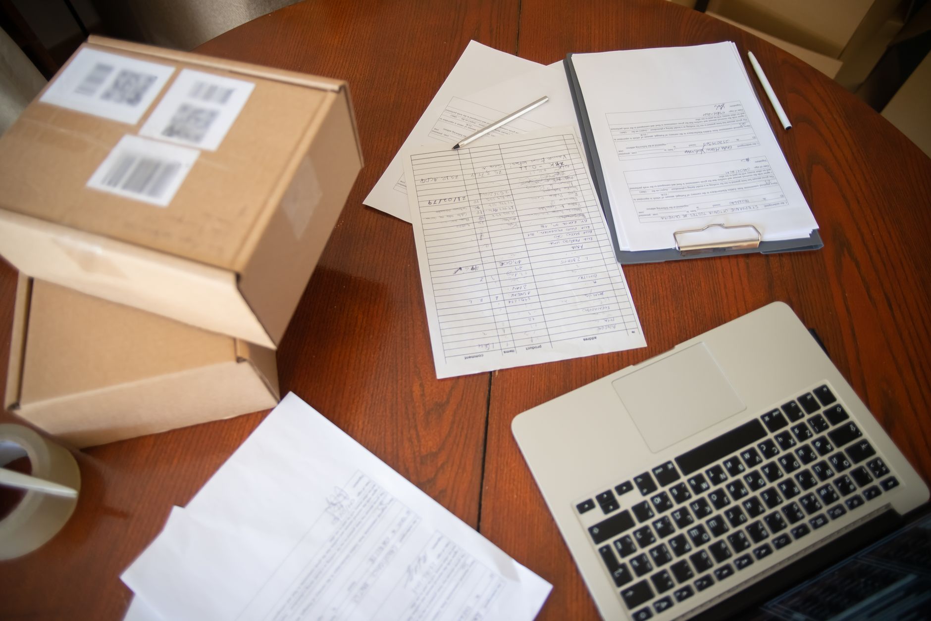 Flat lay of a workspace with laptop, documents, and cardboard boxes for e-commerce operations — illustrating: Central Florida IT Solutions for Manufacturing and Healthcare SMBs | International Green Team, LLC